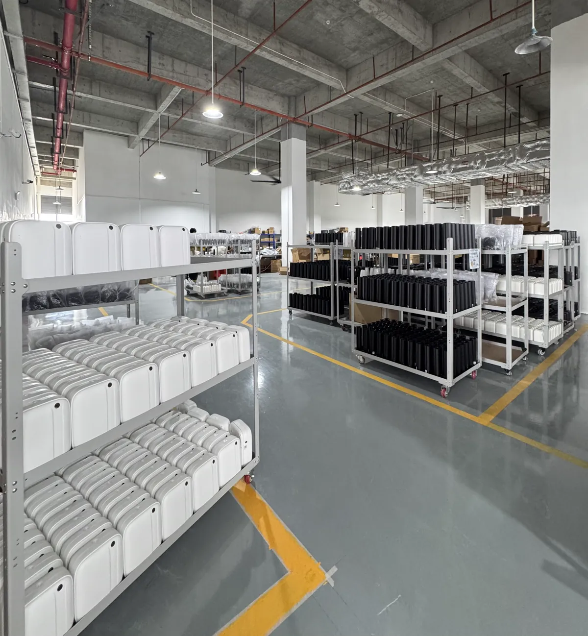 Black and white scent machine units grouped on mobile racks for batch preparation